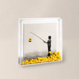 QUADRO PESCADOR DE PATOS ACRÍLICO AMARELO - 25X25CM